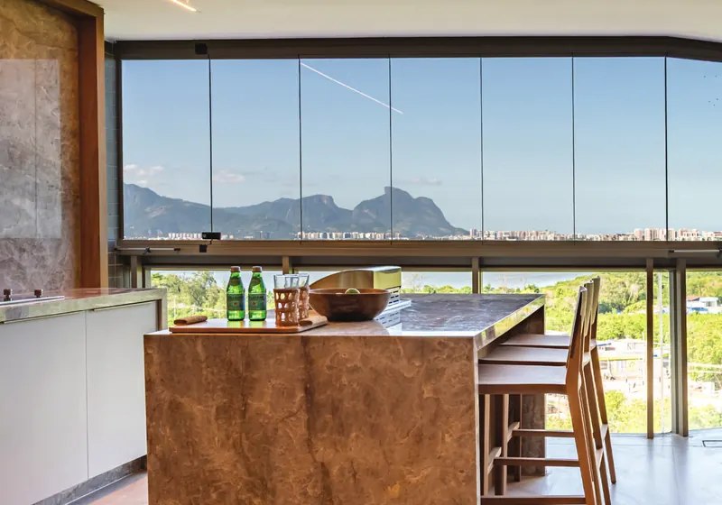 Sala do apartamento decorado do ORO Ilha Pura by Ornare com vista para a lagoa e a Pedra da Gávea